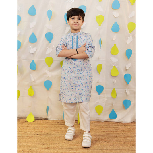 Child wearing a light blue kurta with white pants.