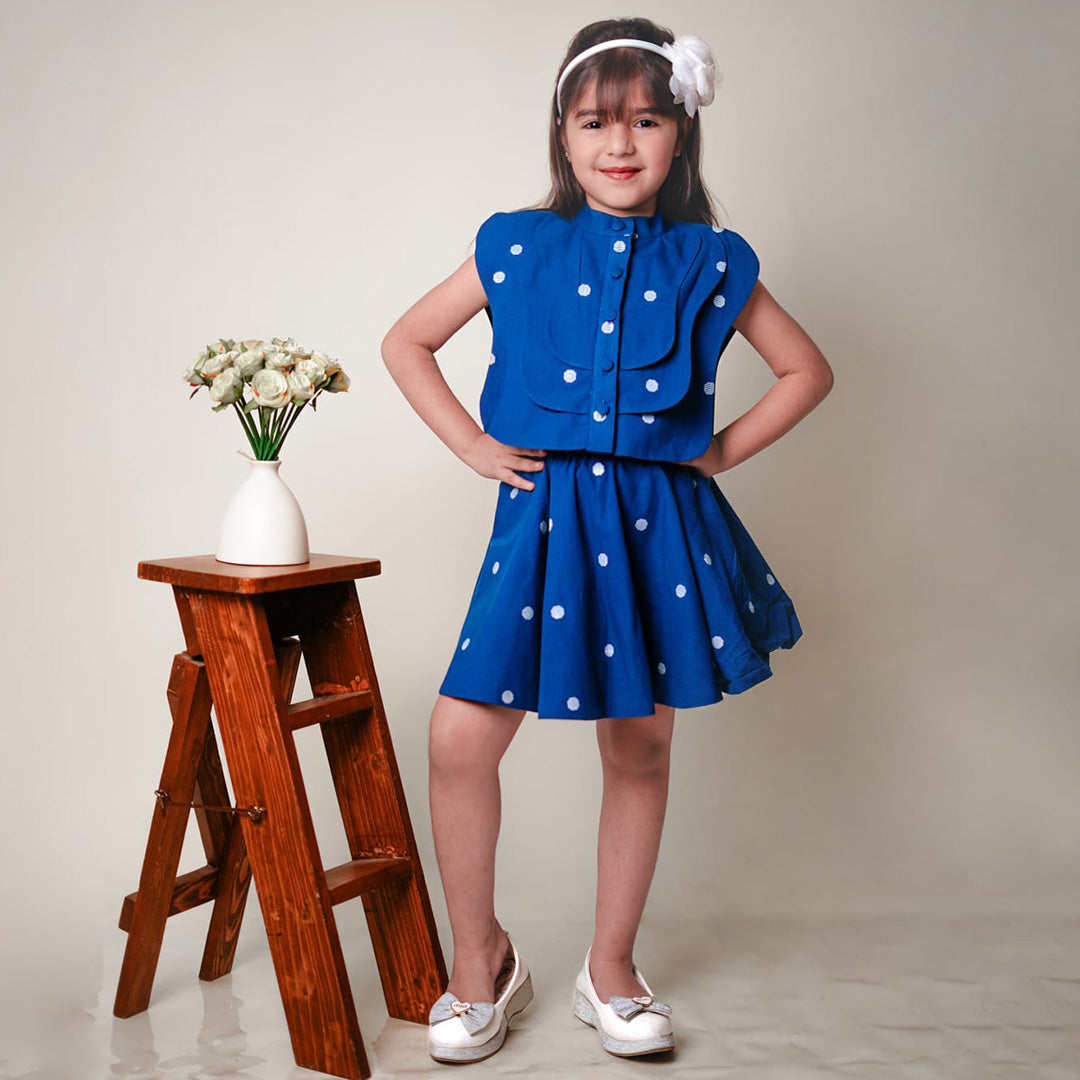Young girl in a blue polka dot dress.