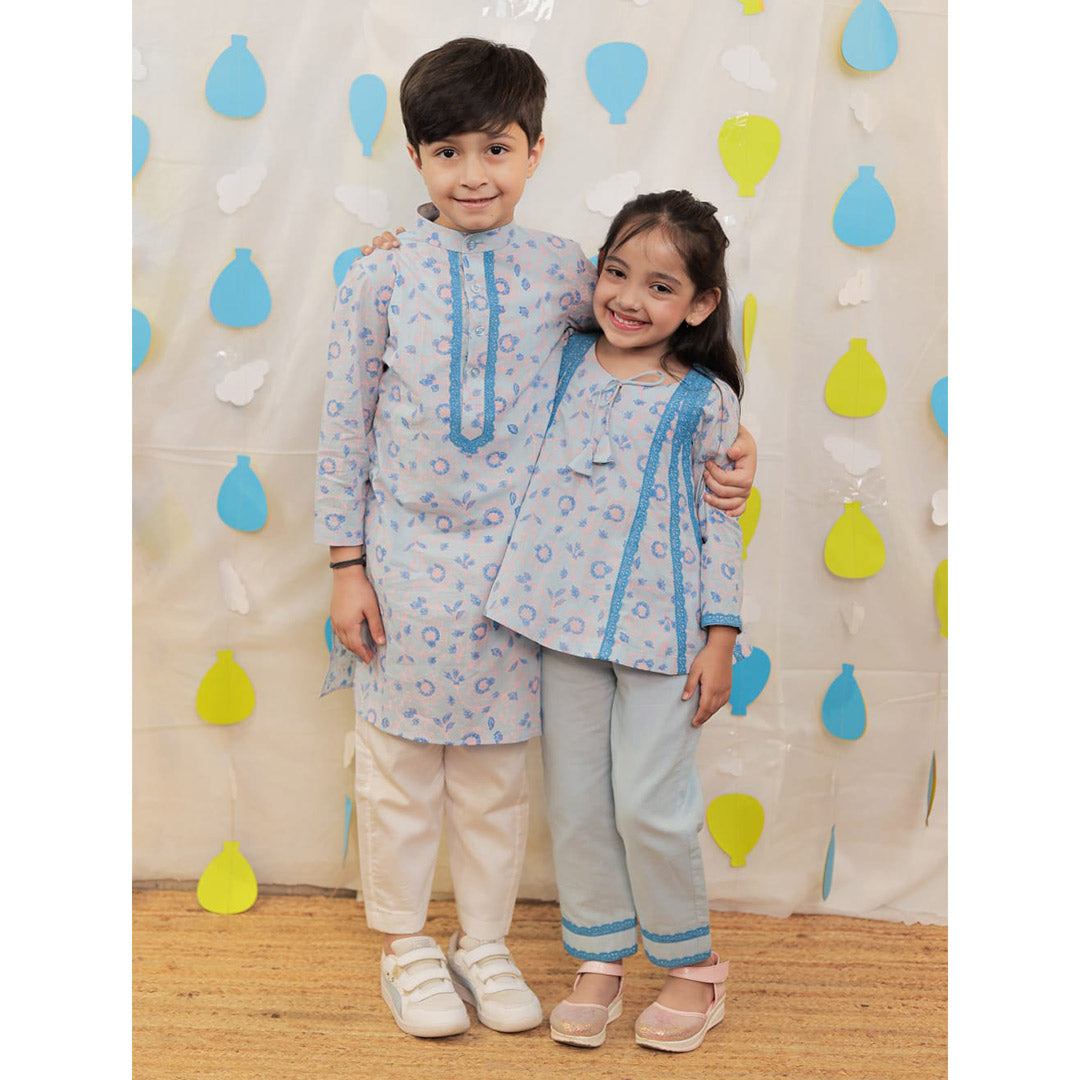 Siblings twining in matching outfits.