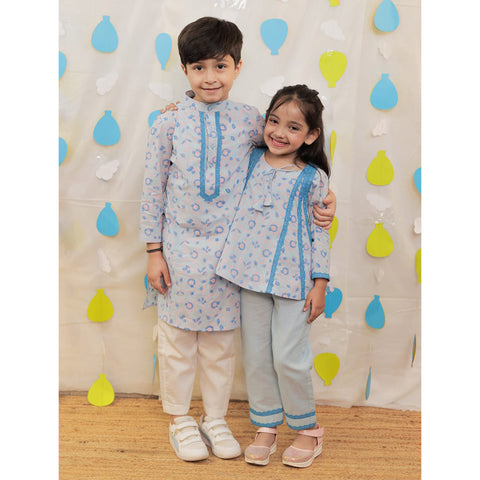 Siblings twining in matching outfits.