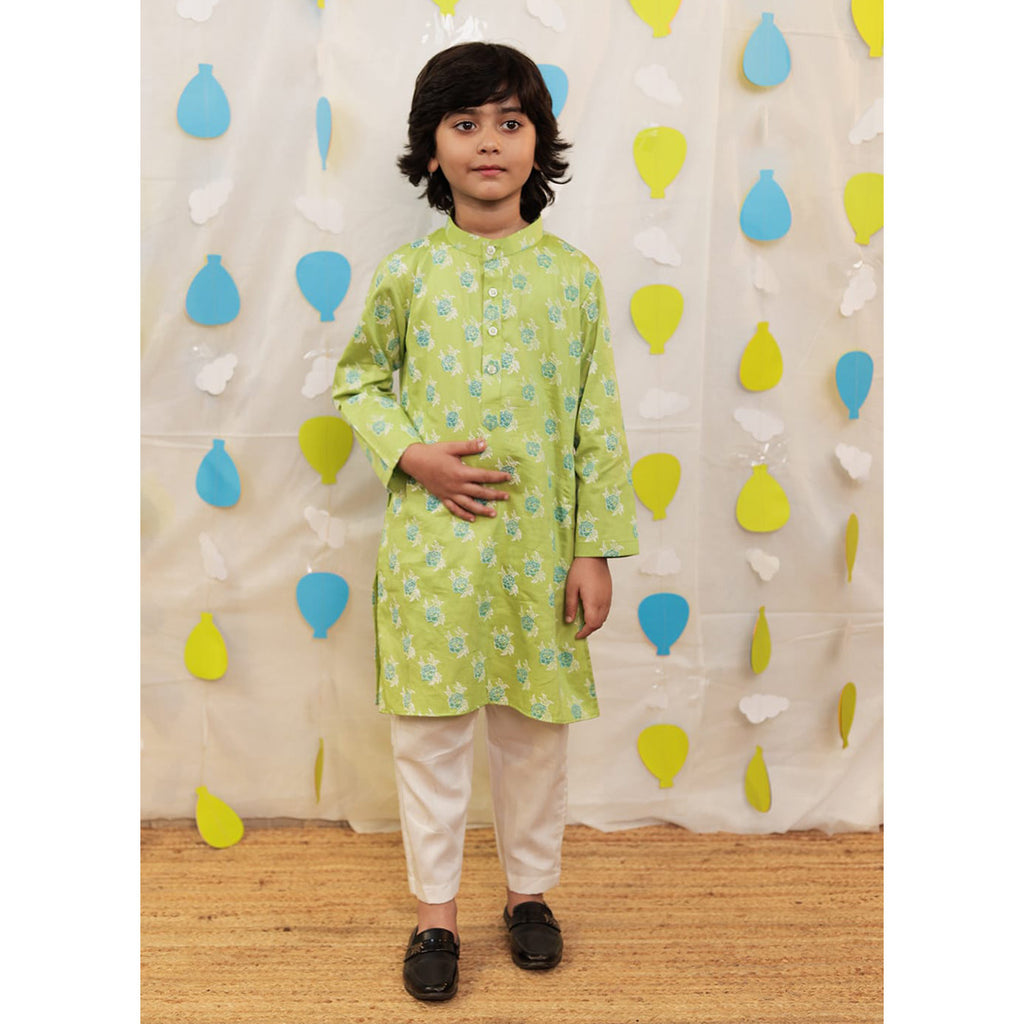 Boy wearing a green kurta with white pants.