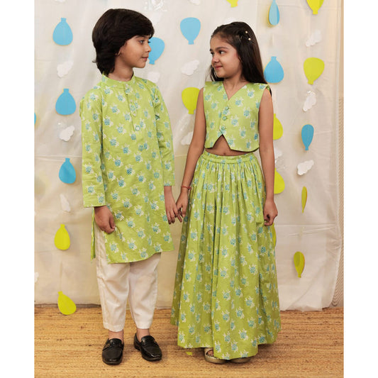 Two children in matching green outfits.