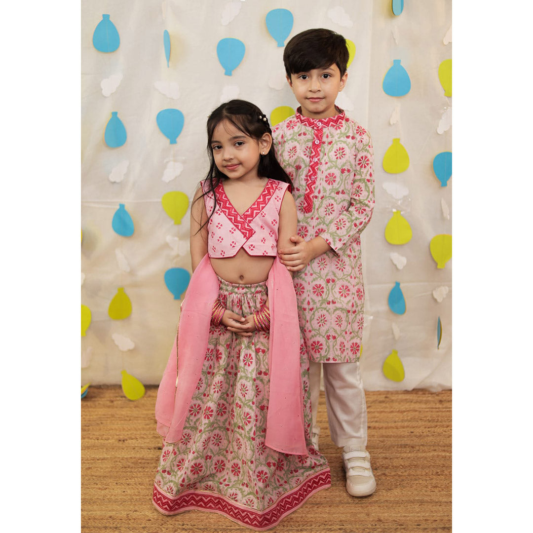 Two children in matching floral outfits.